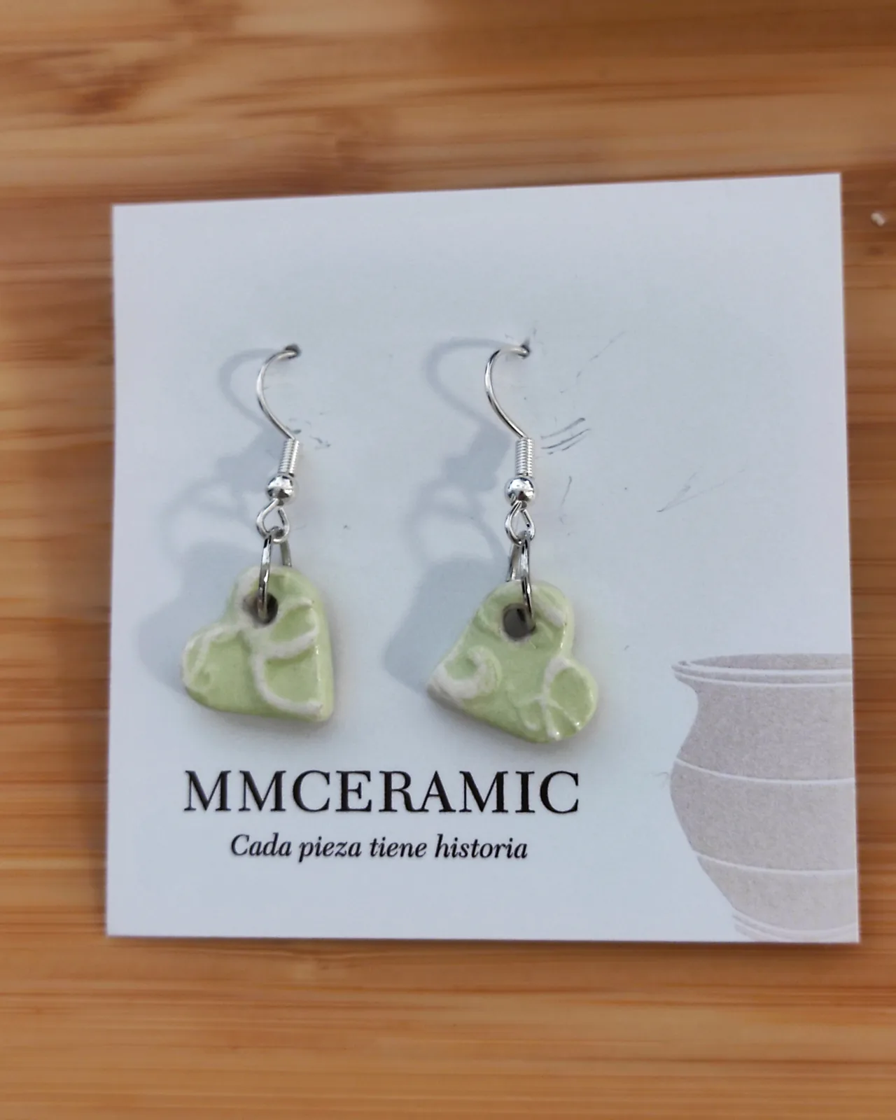 Pendientes de cerámica en forma de corazón, con esmalte verde jaspeado y gancho de plata, sobre tarjeta MMCERAMIC